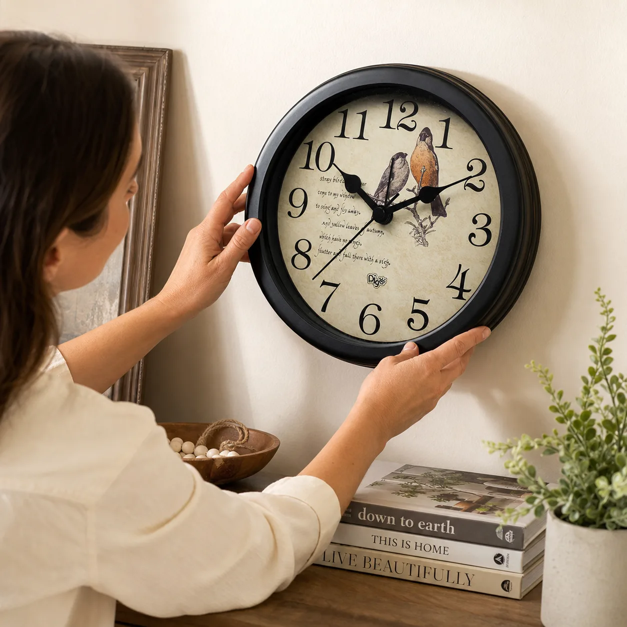 Vintage Bird Wall & Desk Clock being positioned on a console wall Vintage Bird Wall & Desk Clock being positioned on a console wall