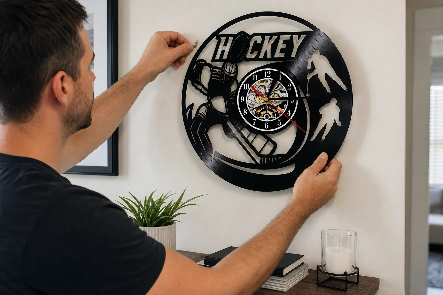 Hockey Vinyl Clock Being Hung on Wall Person hanging a black hockey themed vinyl record wall clock on a clean home wall